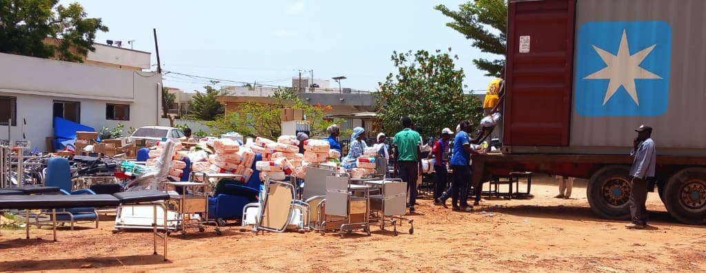 Unloading a container onto red dirt in Senegal